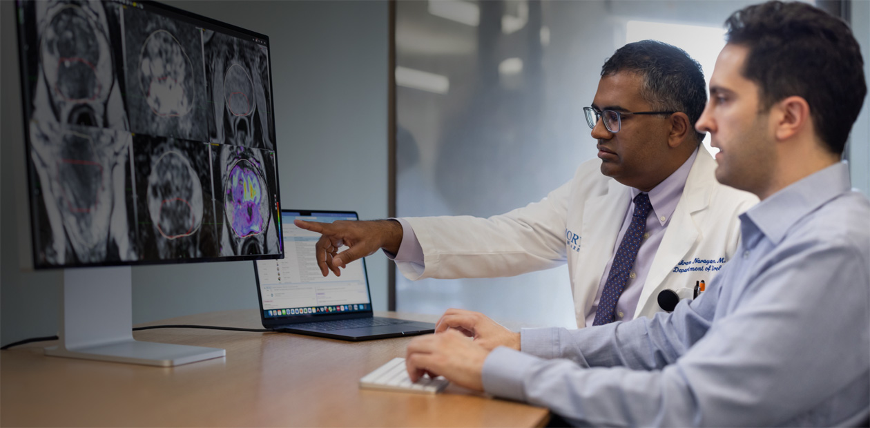 Due medici che guardano immagini radiologiche su un Mac.