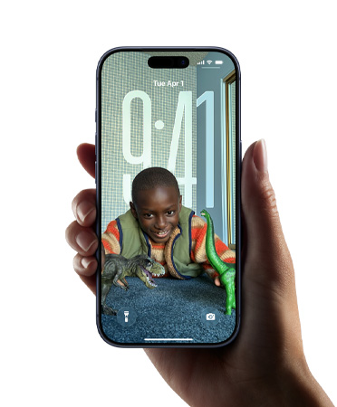 Dłoń trzymająca iPhone’a z nowym dizajnem Liquid Glass, który sprawia, że rozmiar godziny płynnie dopasowuje się do zdjęcia na ekranie blokady